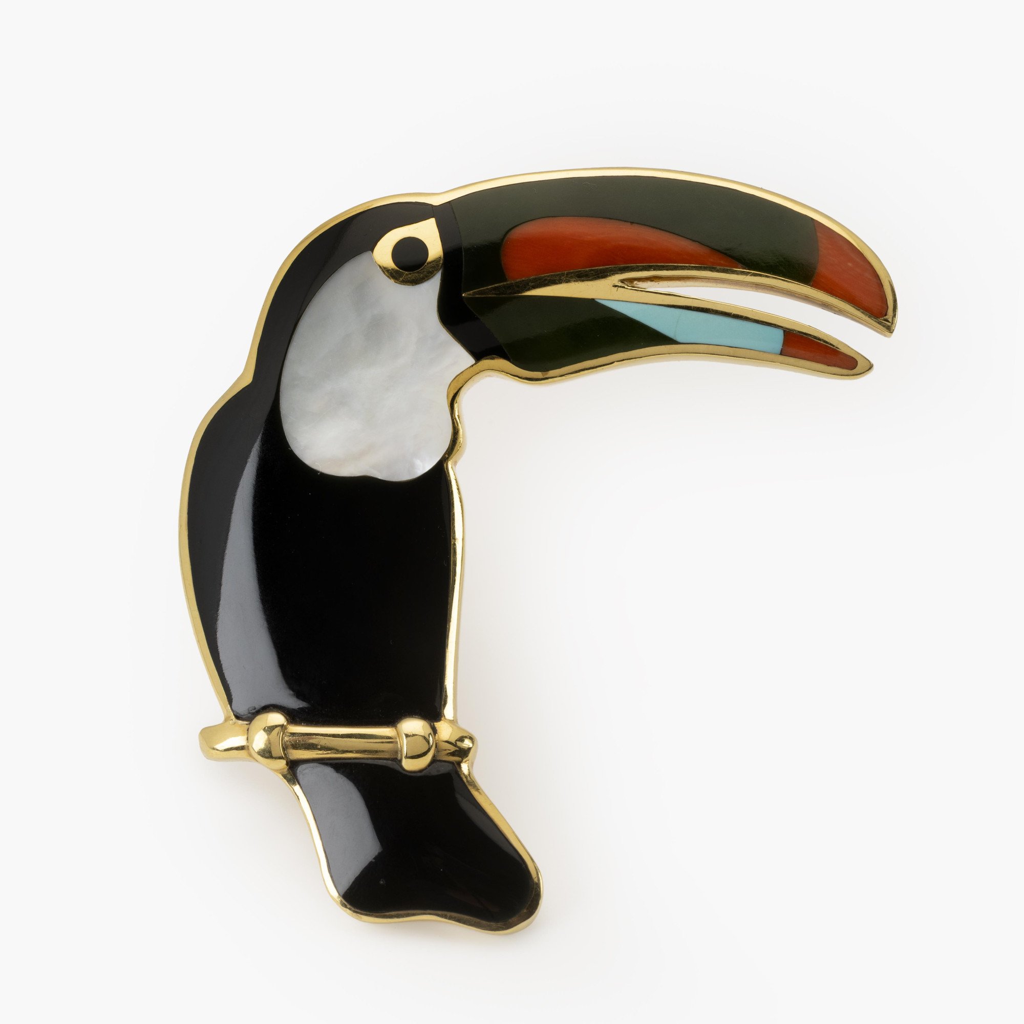 Een achttien karaat geelgouden broche in de vorm van een toekan, ingelegd met zwarte jade, parelmoer, koraal, nefriet en turkoois. Tiffany & Co., ca 1980.