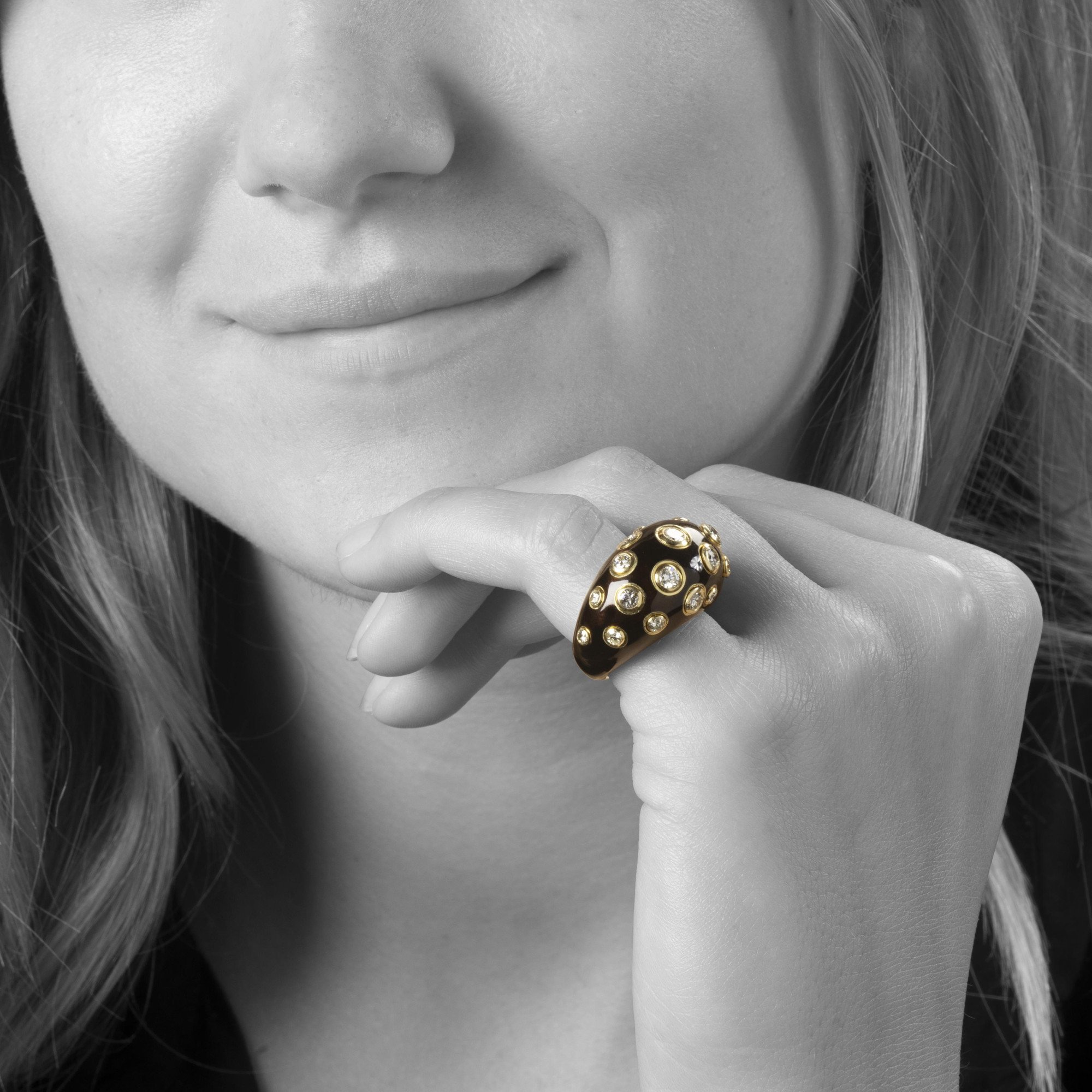 Een achttien karaat geelgouden bolle ring, met bruin emaille en briljant geslepen diamant. Gesigneerd Christian Dior, vervaardigd omstreeks 1980.