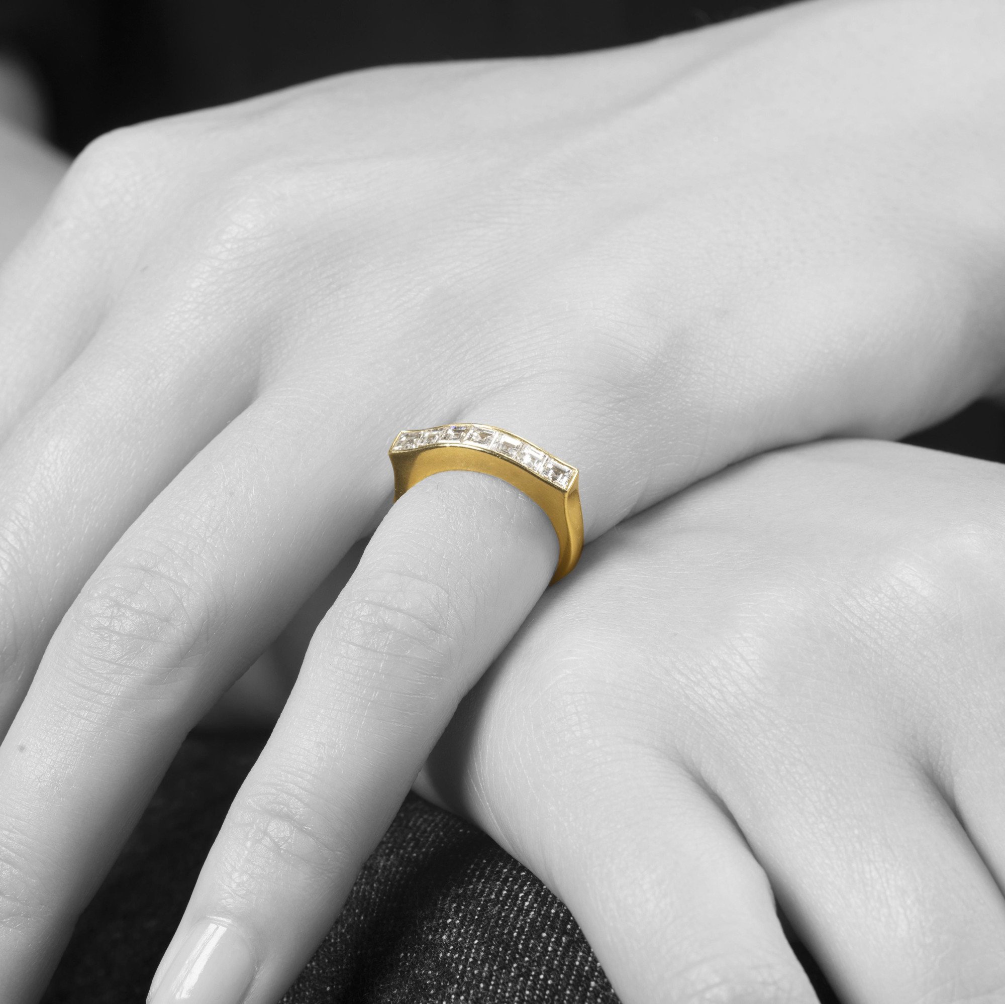 Een achttien karaat geelgouden rechte rijring, in railzetting bezet met zeven carré geslepen diamanten. Gesigneerd Cartier Paris en genummerd.