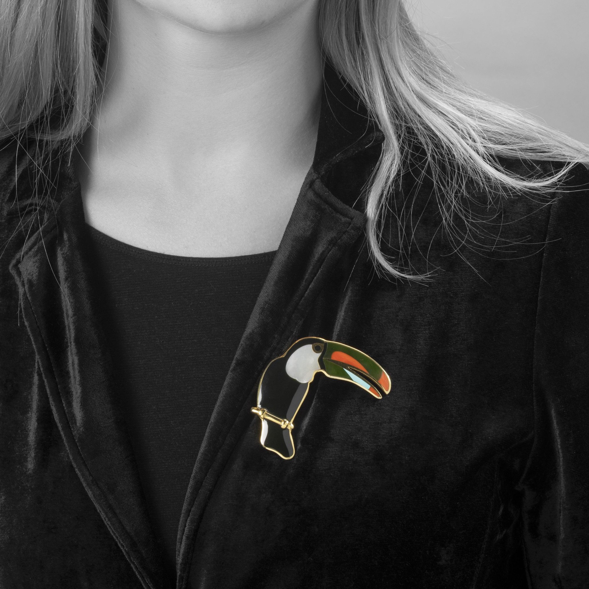 Een achttien karaat geelgouden broche in de vorm van een toekan, ingelegd met zwarte jade, parelmoer, koraal, nefriet en turkoois. Tiffany & Co., ca 1980.